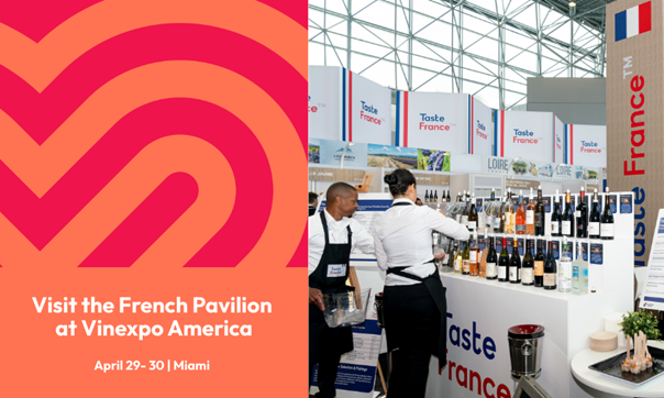 Man & woman setting up a booth at a conference with a variety of alcohol.