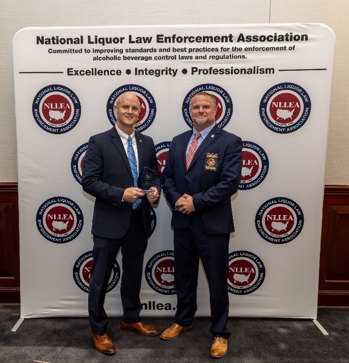 Two men standing in front of a large backdrop