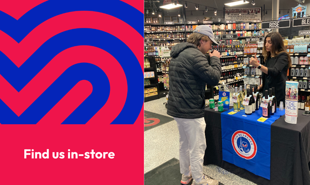 A man standing at a table in a liquor store tasting sample alcohol beverages.